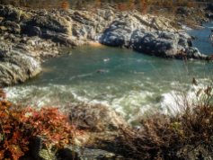From a rocky bluff overlooking the Potomac River Gorge, two kayakers practice their skills in the quieter waters bordering the rapids.